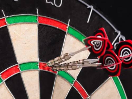 Sisal dartbord met pijlen in de triple 20