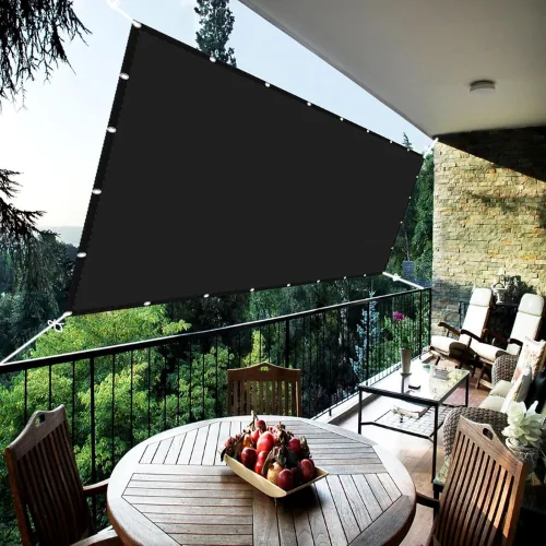 Zwart schaduwdoek aan het hek van een balkon