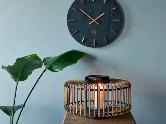 Wandklok als decoratie naast een plant