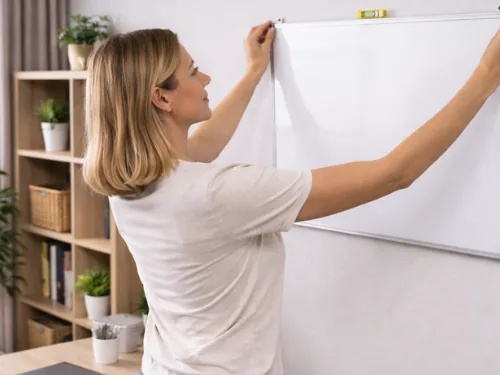 Vrouw hangt een whiteboard op