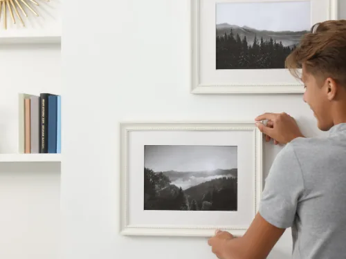 Witte lijsten met landschapsfoto's ophangen